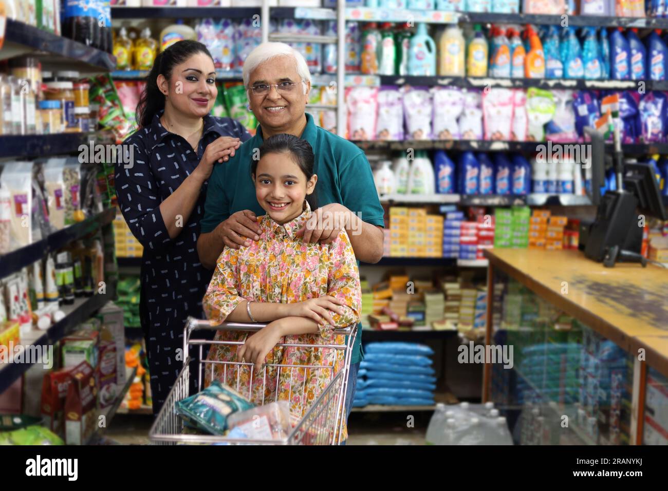 Happy Grandpa and Grand Daughters enjoying purchasing in grocery store. Buying grocery for home in hypermarket. Grand daughter and daughter in law. Stock Photo