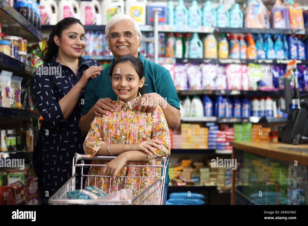 Happy Grandpa and Grand Daughters enjoying purchasing in grocery store. Buying grocery for home in hypermarket. Grand daughter and daughter in law. Stock Photo