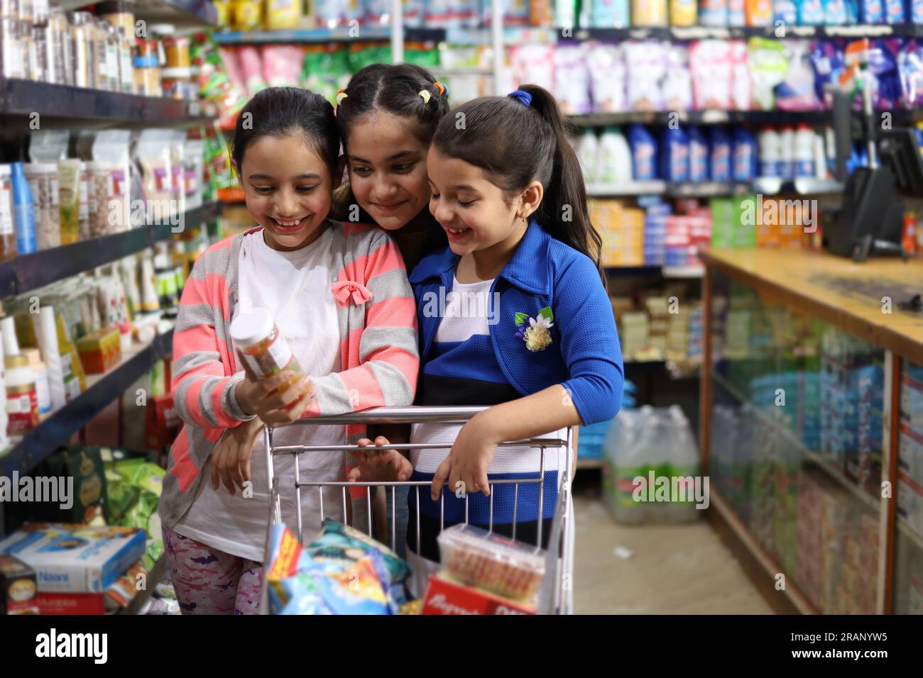Girls children enjoying purchasing in grocery store. Buying grocery for home in supermarket. Joyful Kids buying eatables as per their choice. Stock Photo