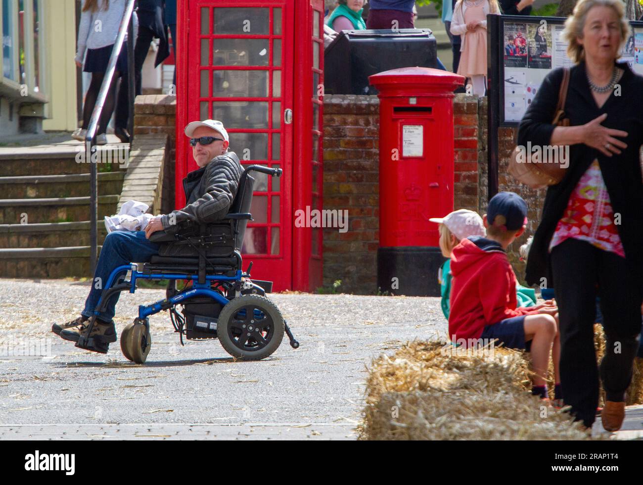 Man in a powered wheelchair and a leather jacket looks isolated in