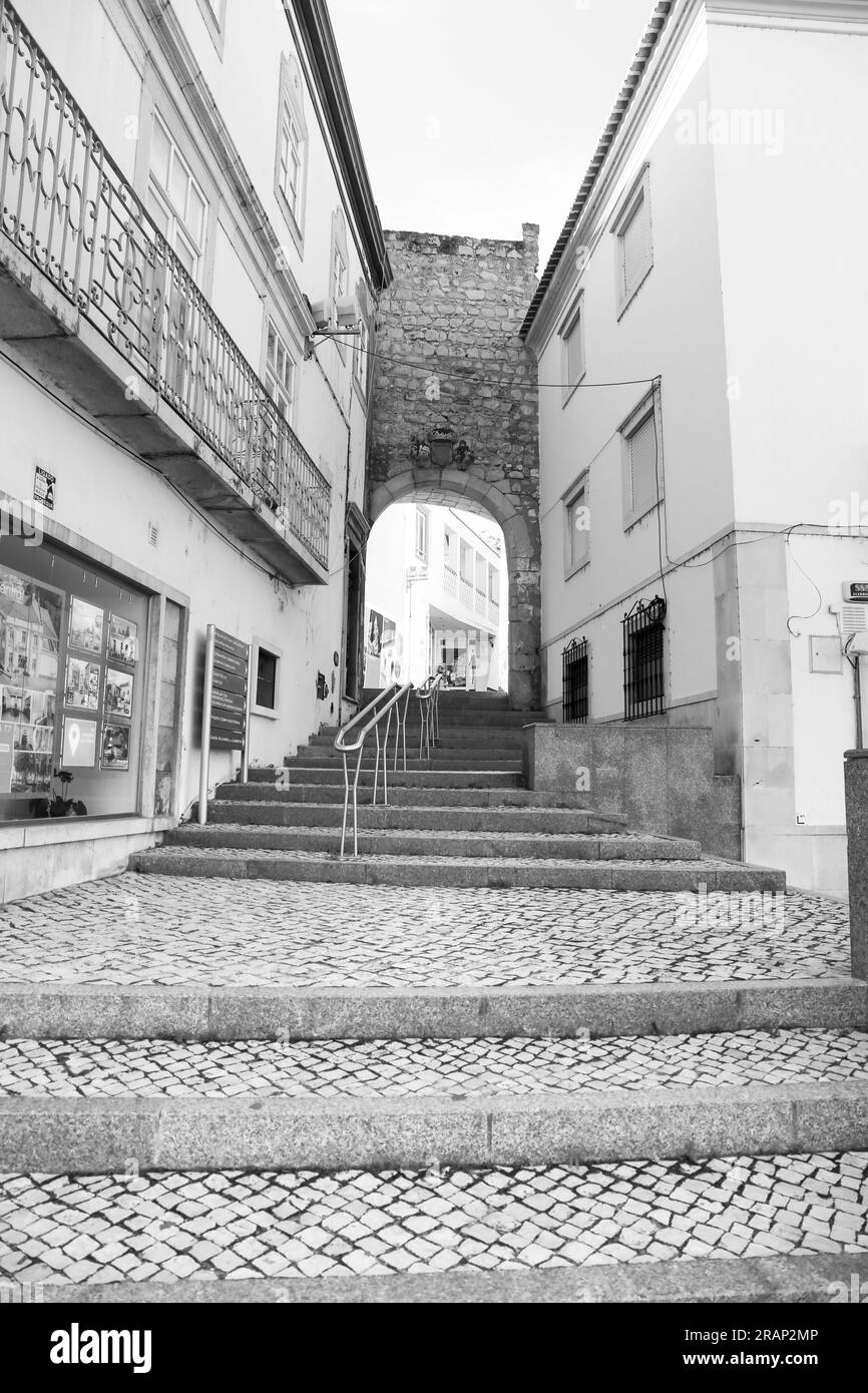 Tavira, Portugal- October 20, 2022: Narrow cobblestone street and traditional facades in Tavira town, Portugal Stock Photo