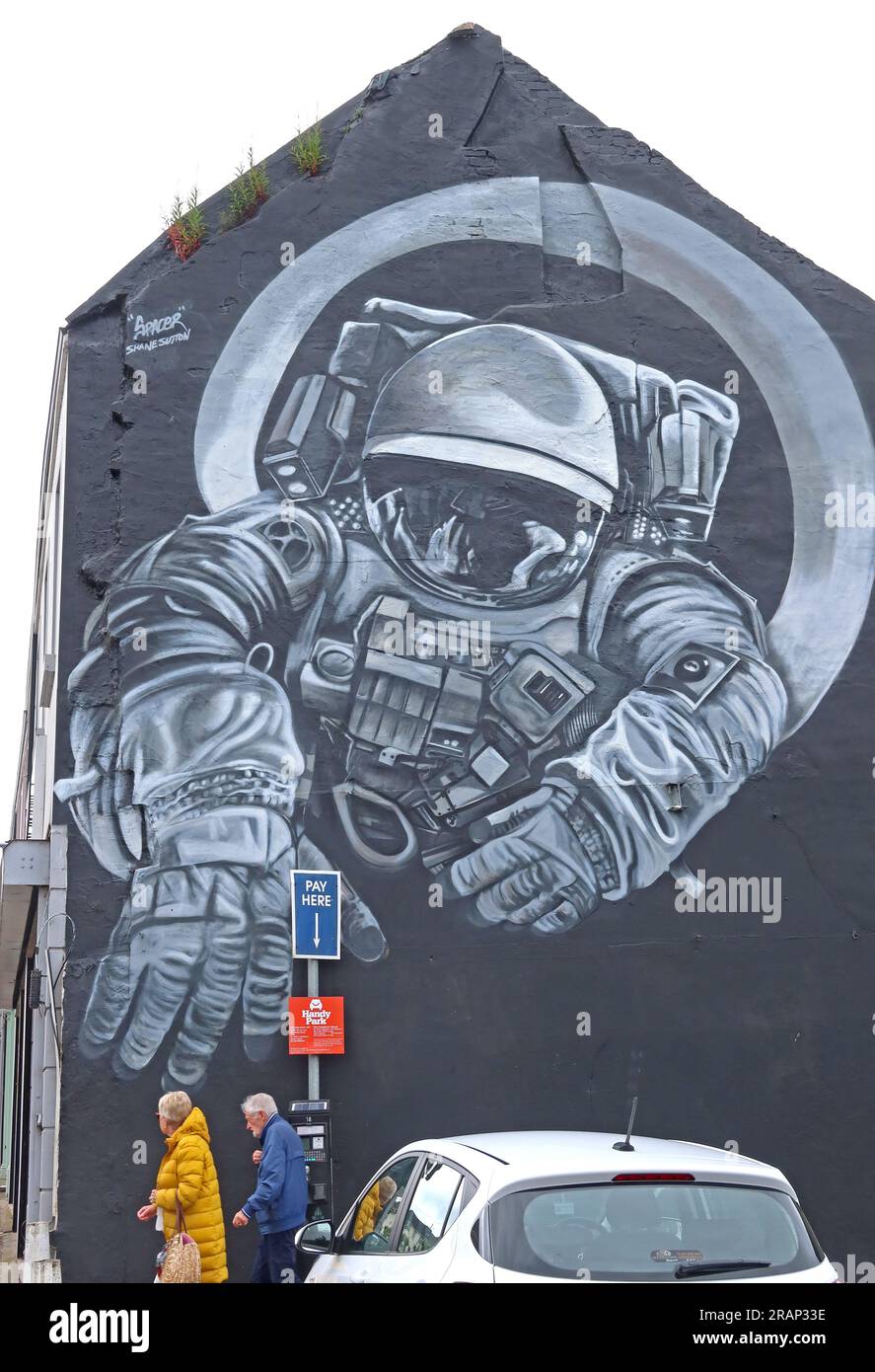 “Spacer” mural by artist Shane Sutton in Coleraine, County Londonderry, Northern Ireland, depicting an astronaut reaching out from a large-scale wall Stock Photo