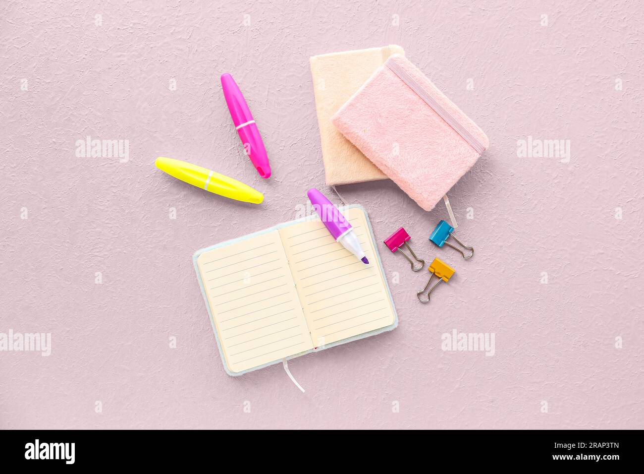 Composition with notebooks, markers and binder clips on light background Stock Photo