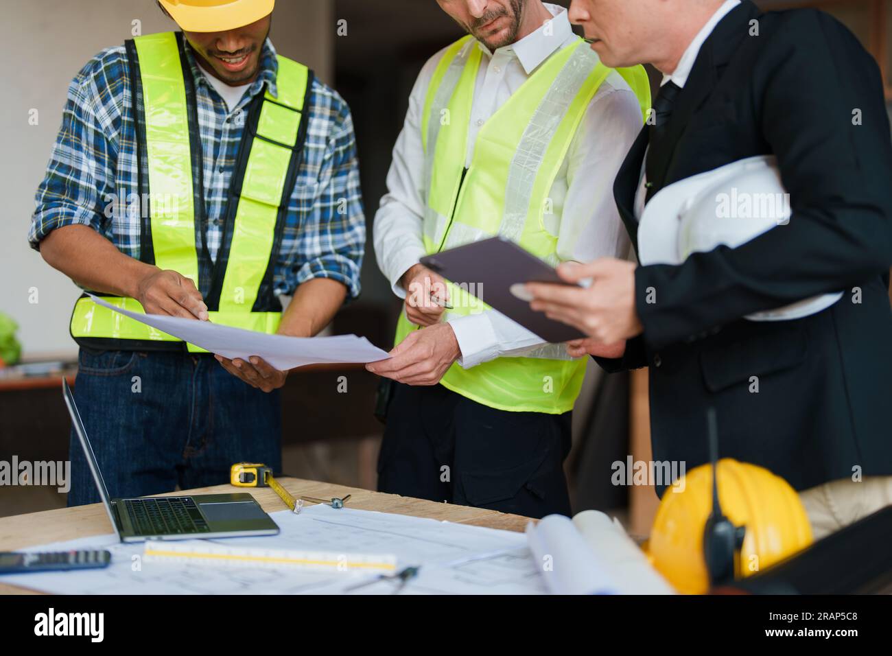 multi ethnic engineer brainstorming and measuring for cost estimating