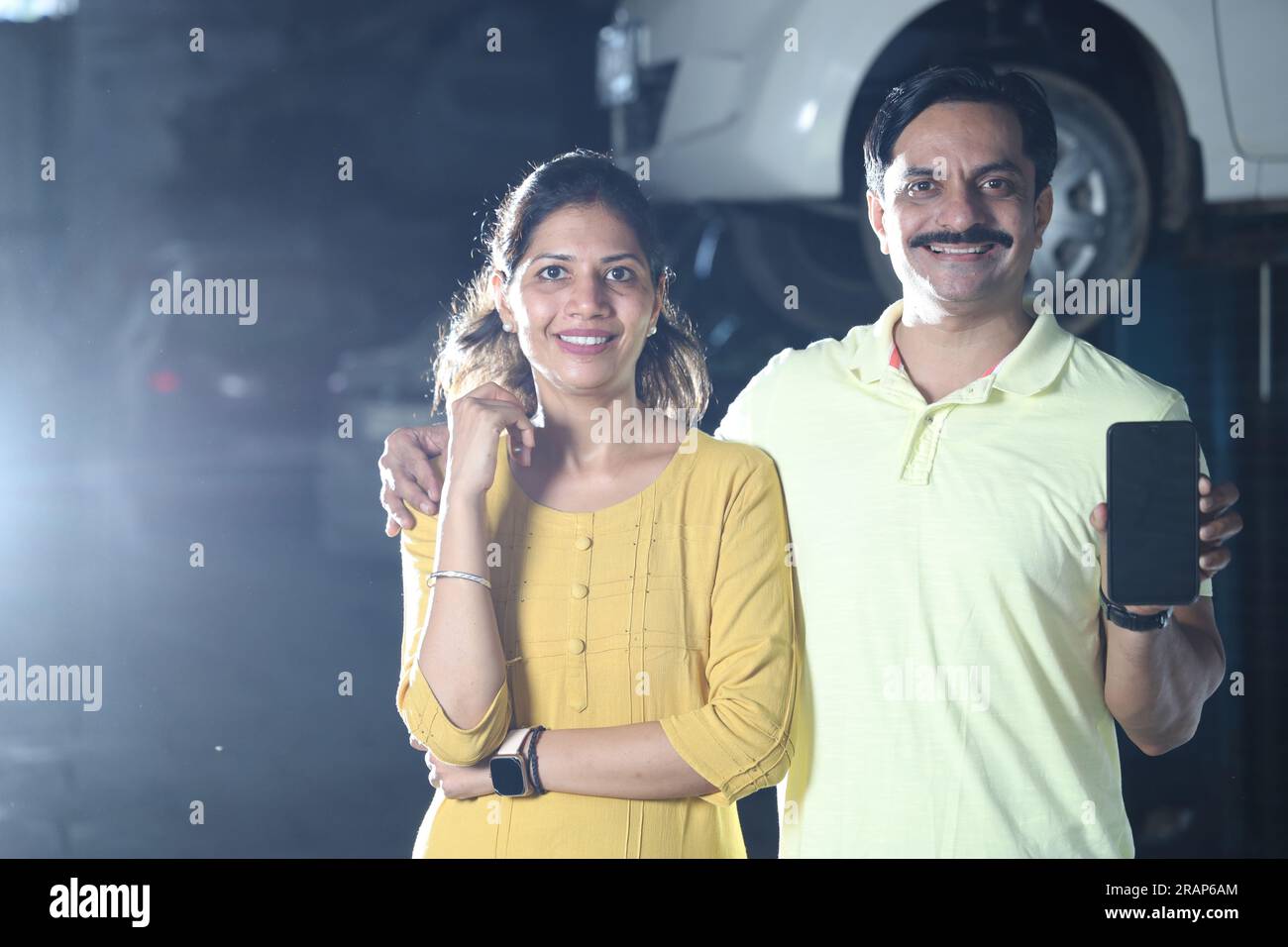 Indian happy customers showing thumbs up for repairing the car with honesty. Portraying customer trust and satisfaction towards the service station Stock Photo