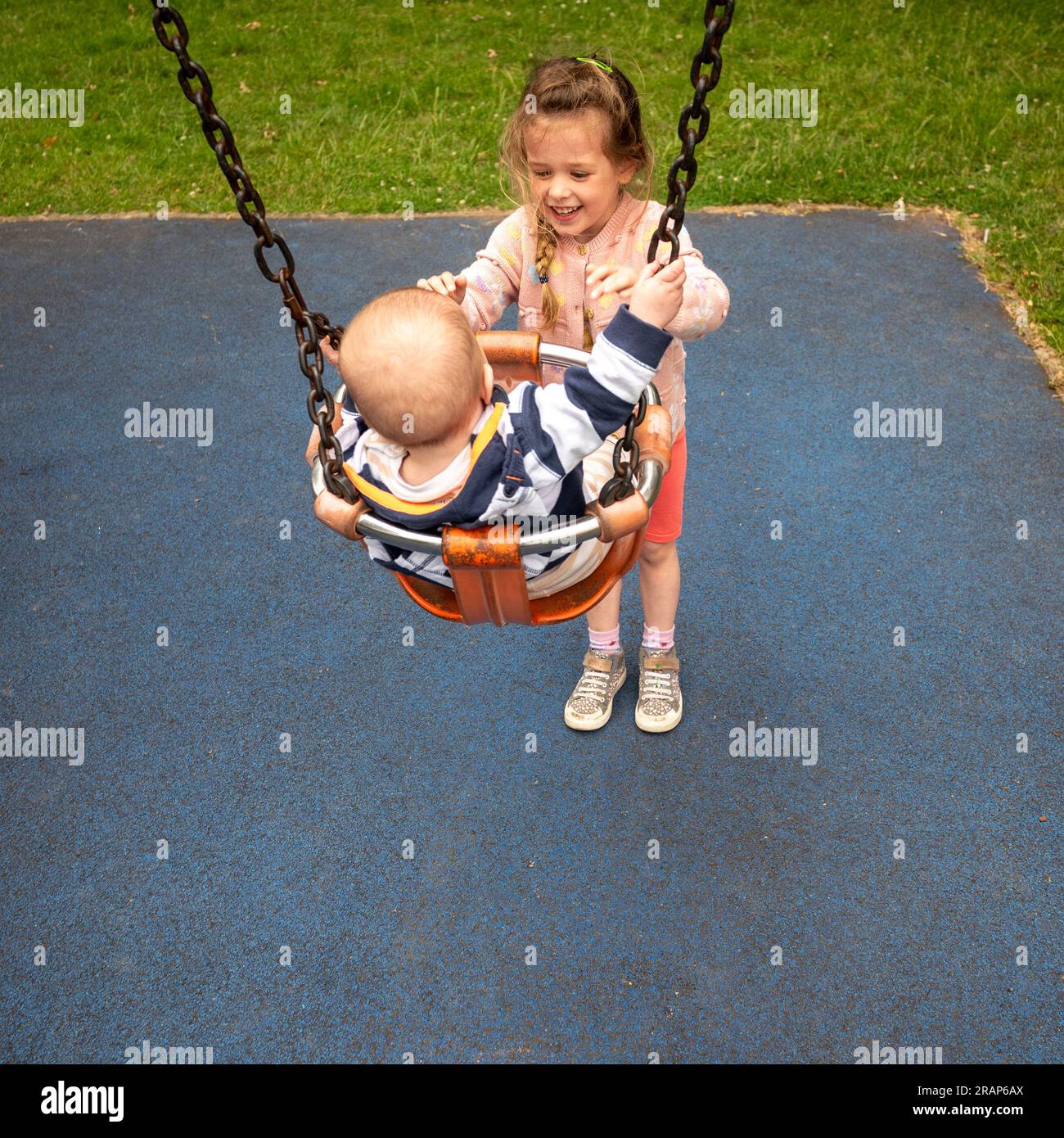 Boy and girl sharing swing on summer day in Sweden Stock Photo - Alamy