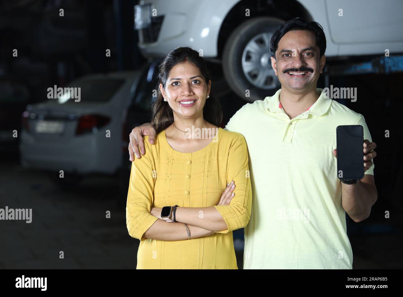 Indian happy customers showing thumbs up for repairing the car with honesty. Portraying customer trust and satisfaction towards the service station Stock Photo