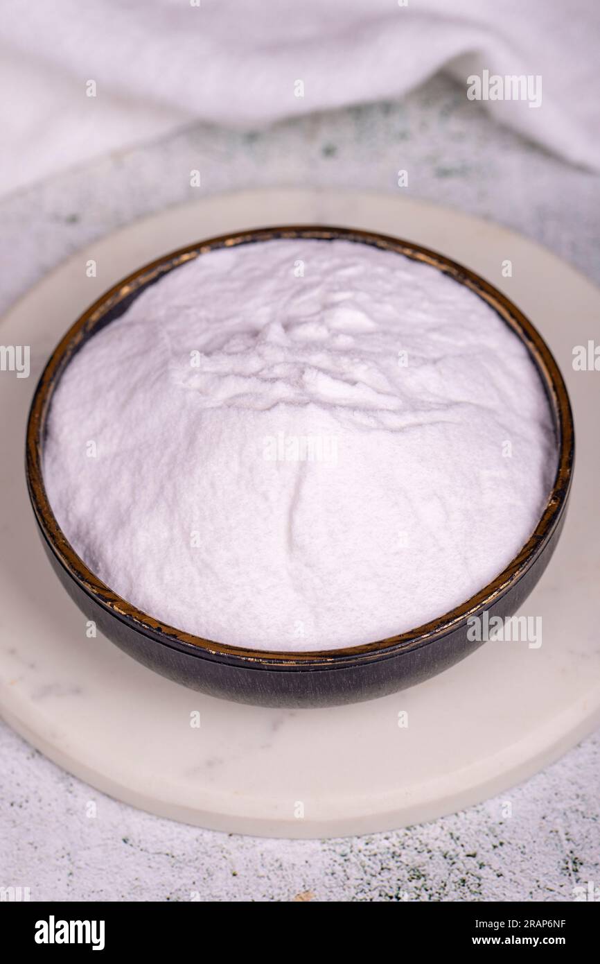 Sodium bicarbonate or baking soda on grey background. Sodium