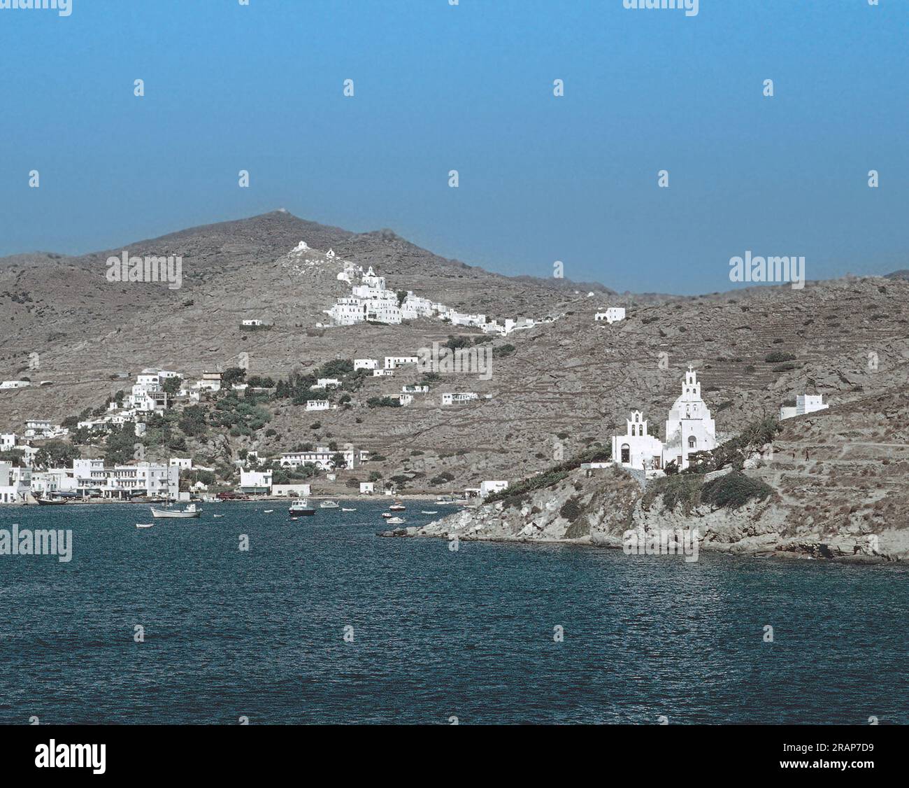 Scanned archival image arriving at a relatively unspoilt and underdeveloped Ios in 1976 featuring the port and the village and the Church of St Irene, Stock Photo