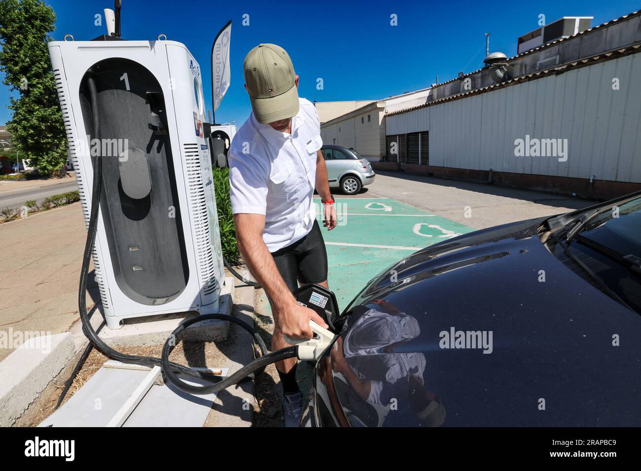 Calvi, France. 05th July, 2023. A man powers-up his electrical vehicle at a charging point on July 5, 2023 in Calvi, Corsica, France. Corsica has become the leader in electric cars in mainland France in terms of the number of clean vehicles per 1,000 inhabitants. Thanks to the recent development of charging stations on the island of beauty. Photo by Shootpix/ABACAPRESS.COM Credit: Abaca Press/Alamy Live News Stock Photo