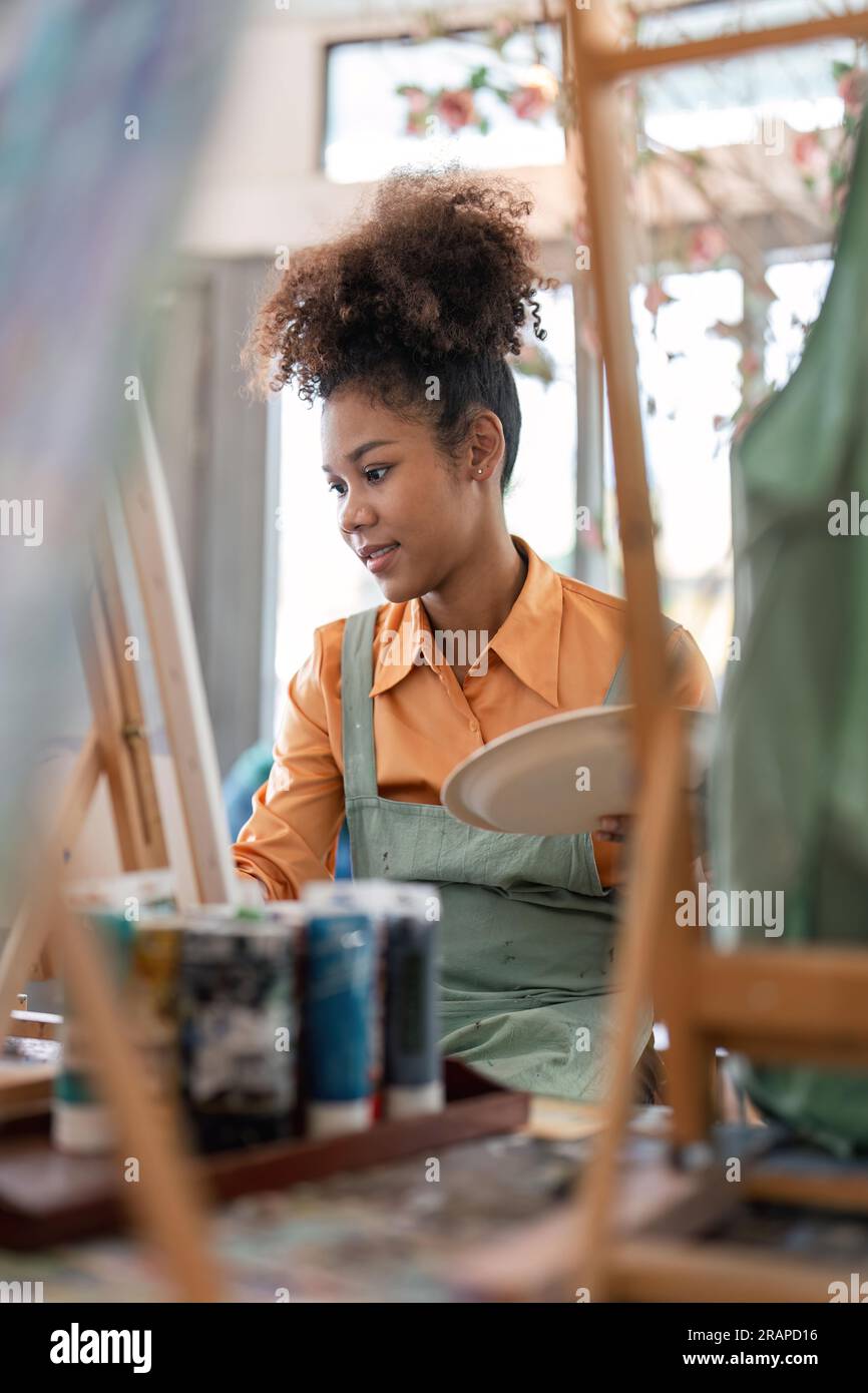 An African American woman who loves art or a female artist is holding a ...