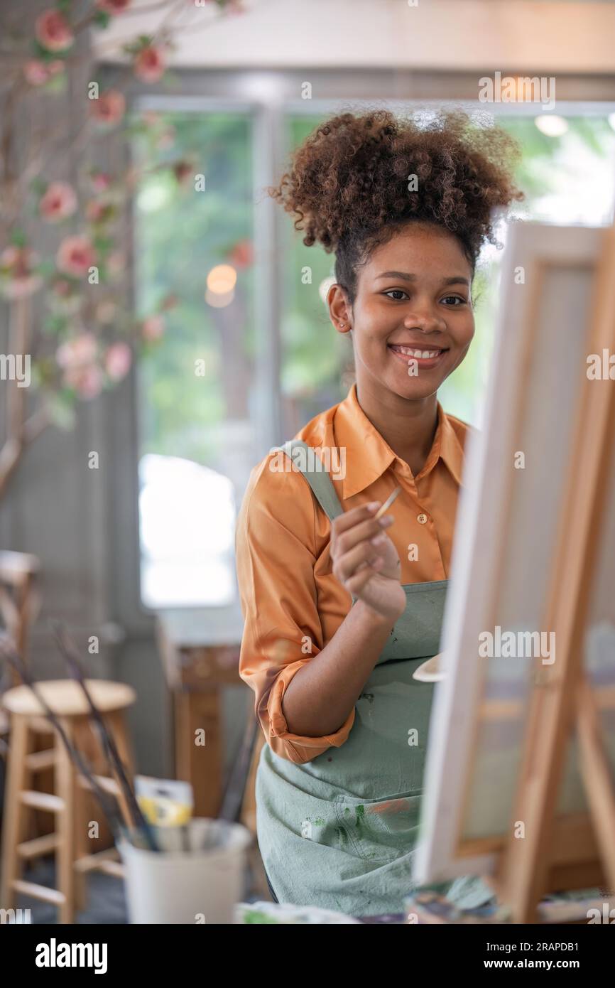 An African American woman who loves art or a female artist is holding a ...