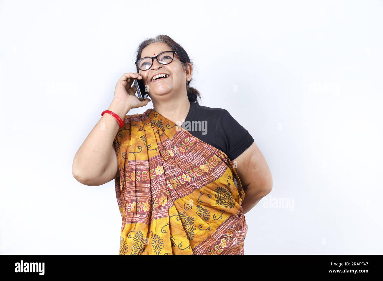 Rural Indian old woman wearing saree portraying various expressions on phone. She is holding a mobile phone. Go digital concept in rural India. Stock Photo