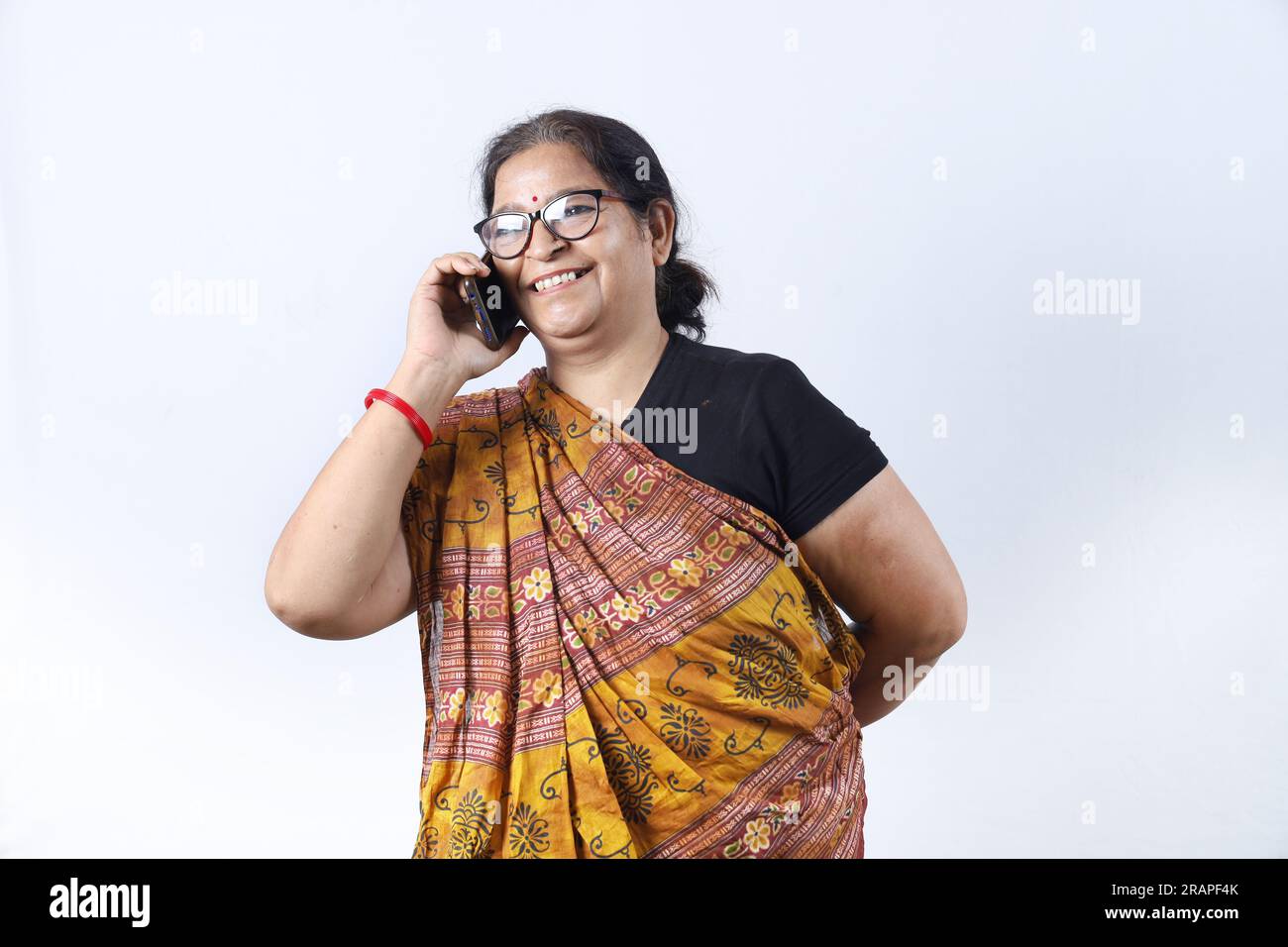 Rural Indian old woman wearing saree portraying various expressions on phone. She is holding a mobile phone. Go digital concept in rural India. Stock Photo