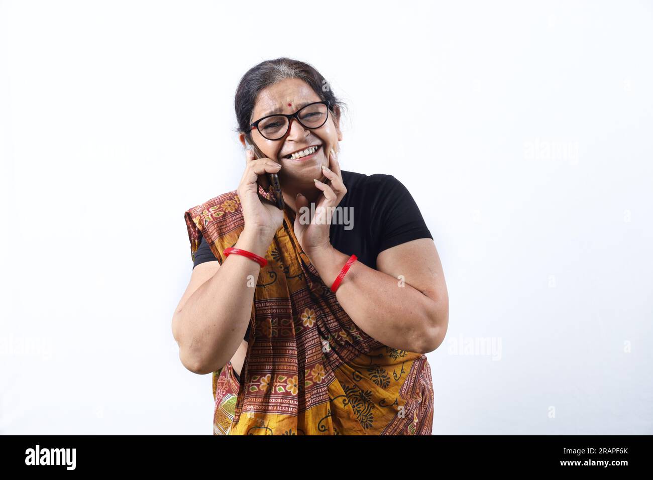 Rural Indian old woman wearing saree portraying various expressions on phone. She is holding a mobile phone. Go digital concept in rural India. Stock Photo