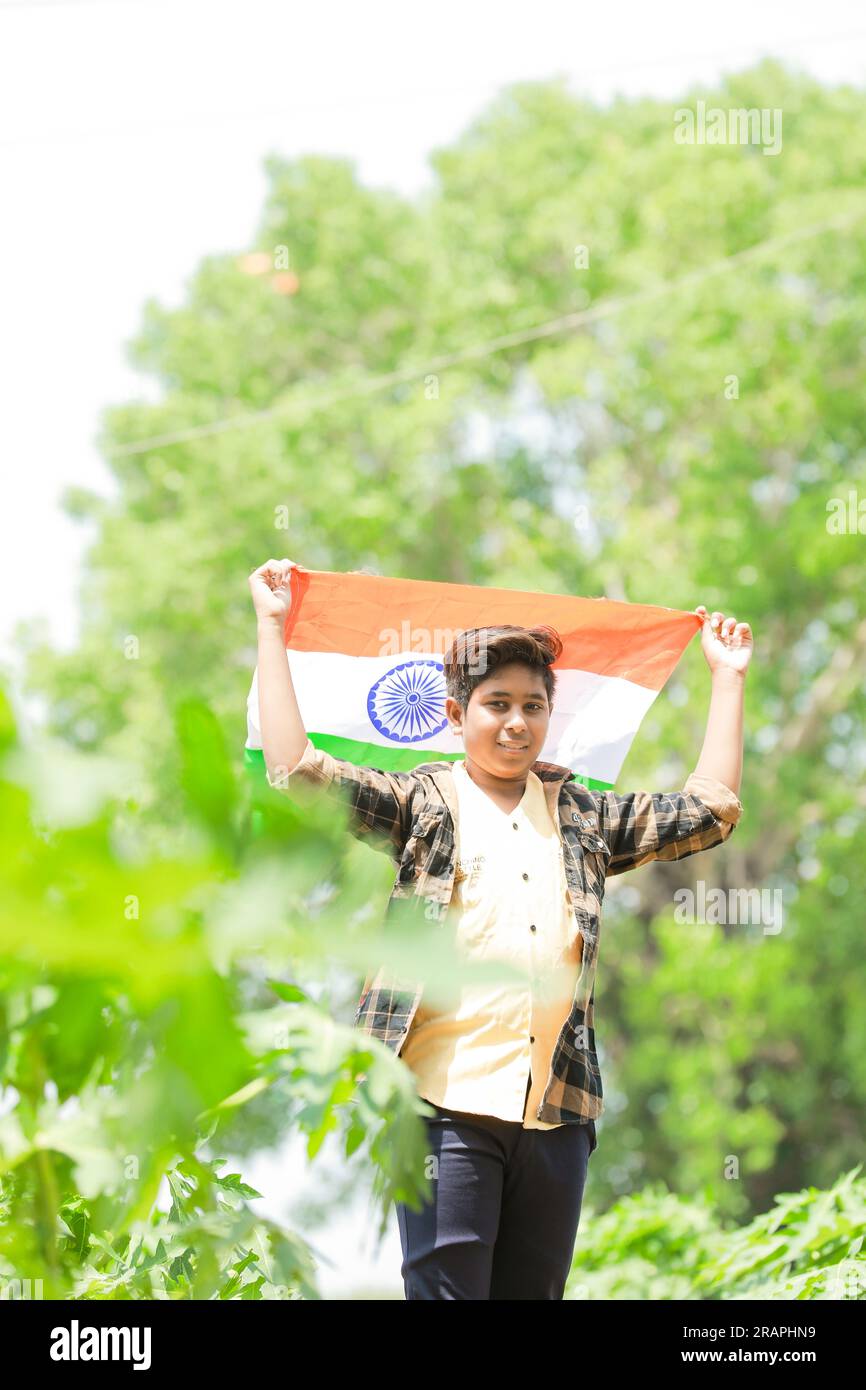 Indian boy holding national flag in farm, happy boy, national flag