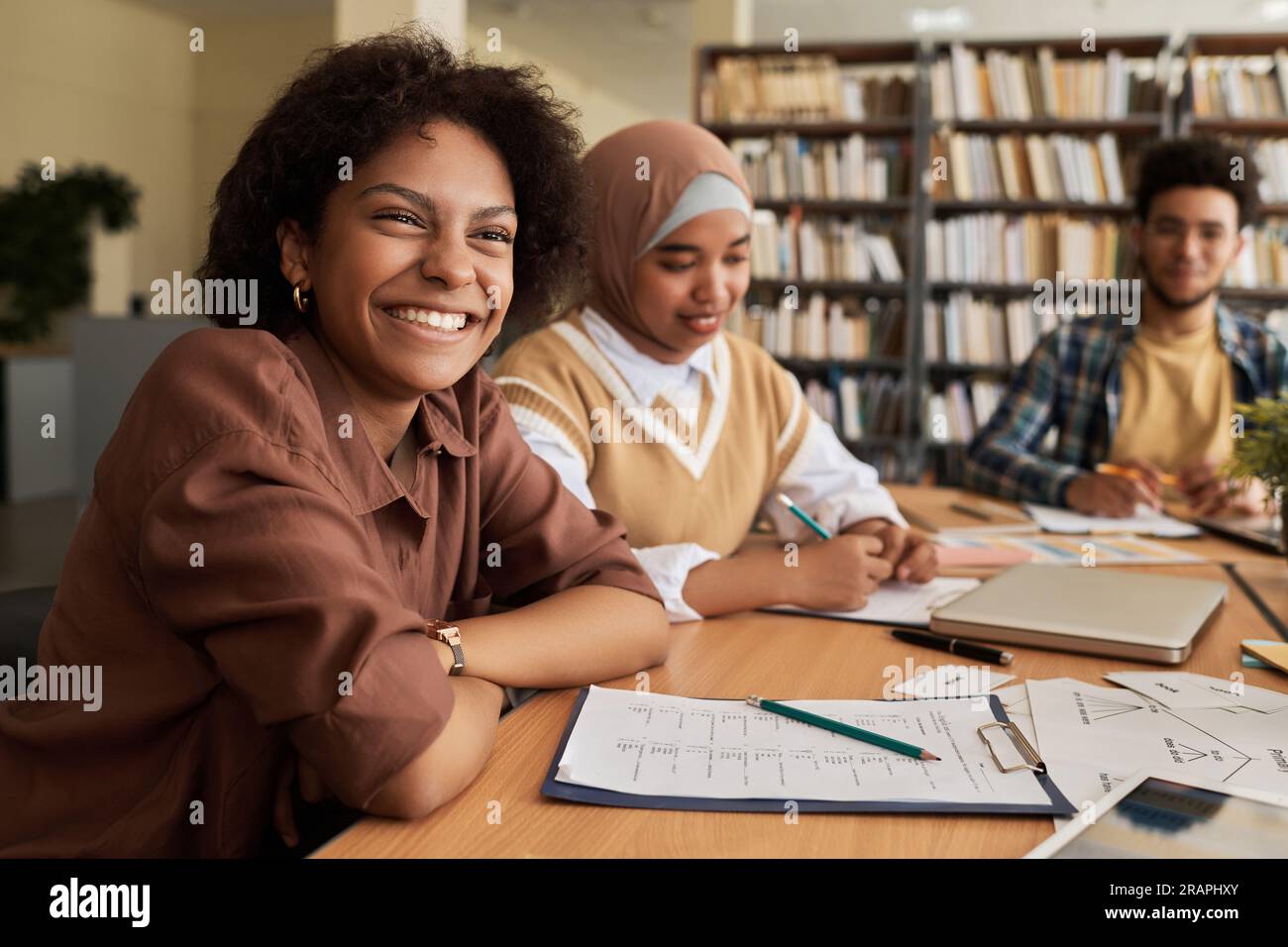 Group of students studying foreign language together at table in library Stock Photo