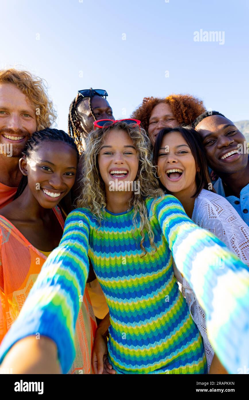 Happy diverse group of friends having party, taking a selfie in garden ...