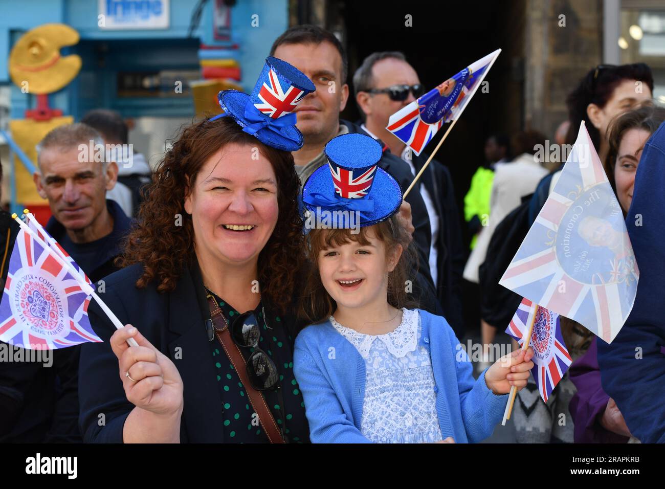 Members of the public wave union flags outside St Giles' Cathedral ahead of the National Service of Thanksgiving and Dedication for King Charles III and Queen Camilla, and the presentation of the Honours of Scotland. Picture date: Wednesday July 5, 2023. Stock Photo