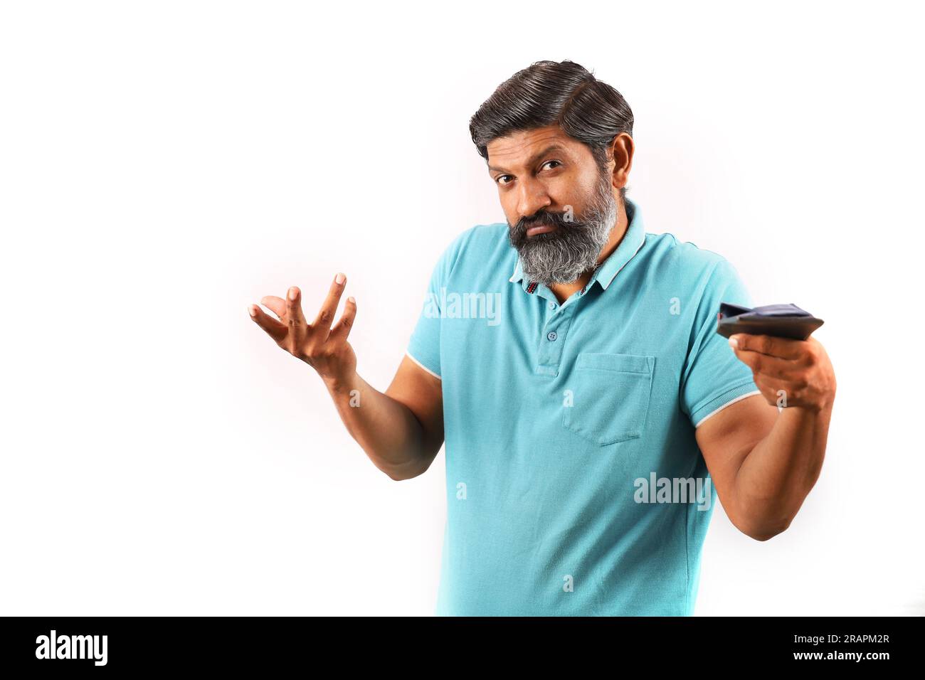 Portrait of an Indian bearded man wearing shirt showing empty wallet. Wacky and Funky expressions white background. poverty and no cash and no money. Stock Photo