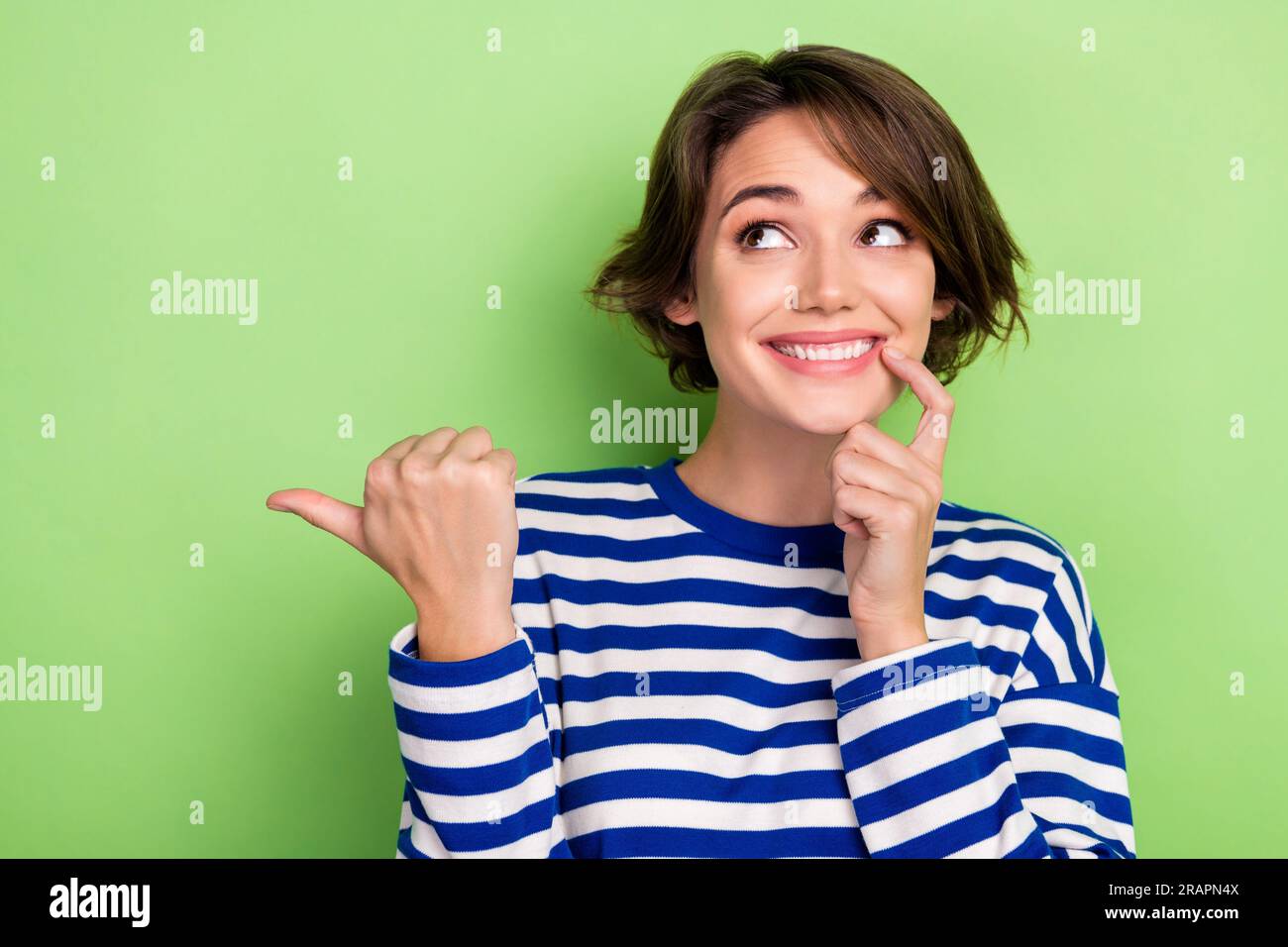 Photo of charming funny girl indicate thumb finger empty space cunning ...