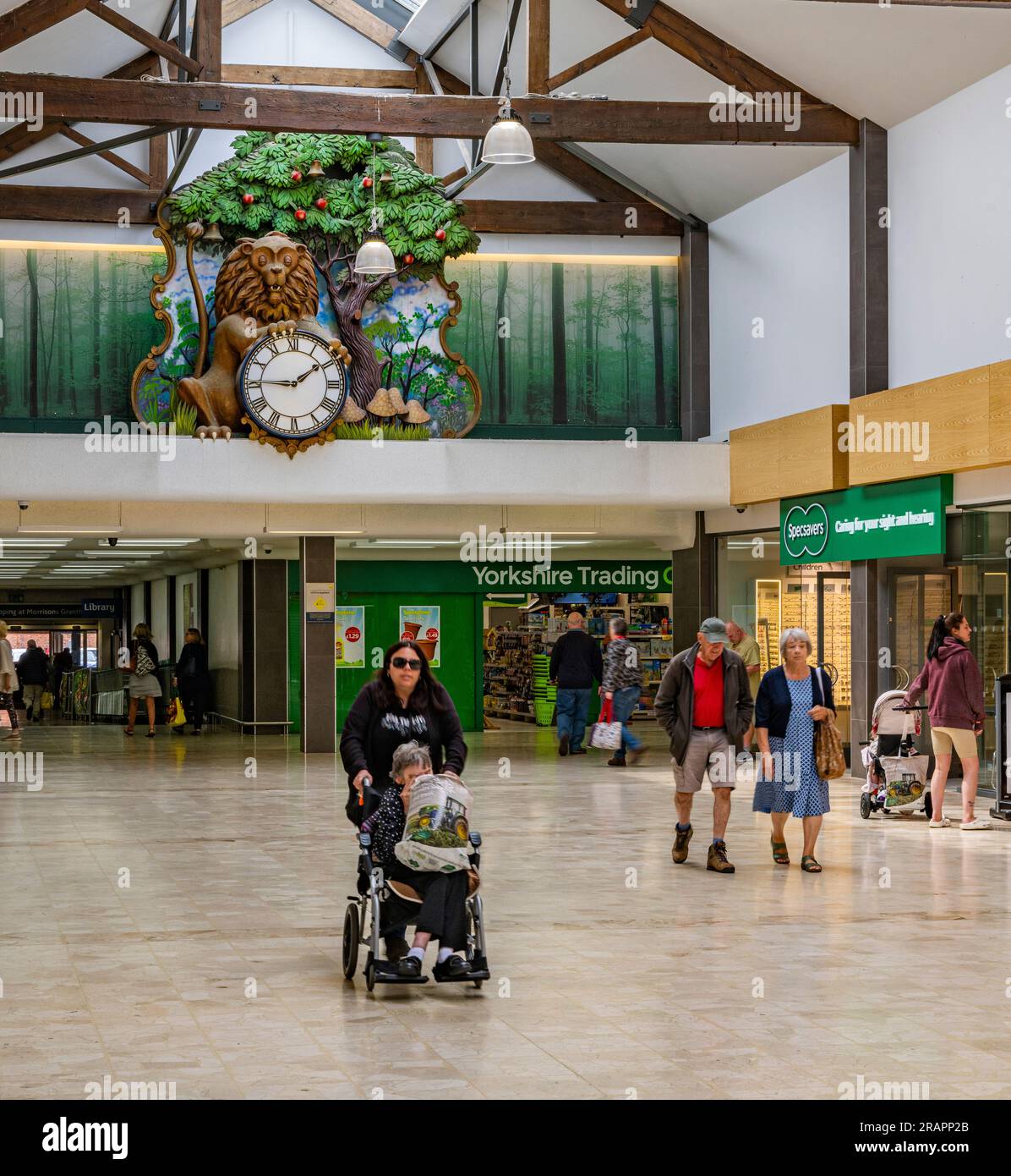 The Isaac Newton Shopping Centre in Grantham, Lincolnshire UK with the famous clock visible on the back wall, where a lion opens its eyes every hour and an apple falls Stock Photo