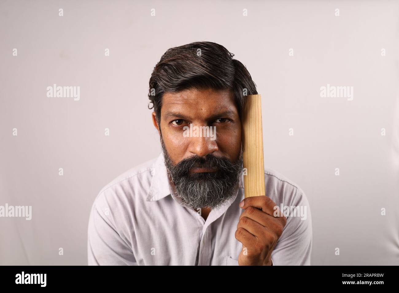 Portrait of an Indian bearded man in anger wearing shirt holding a ...