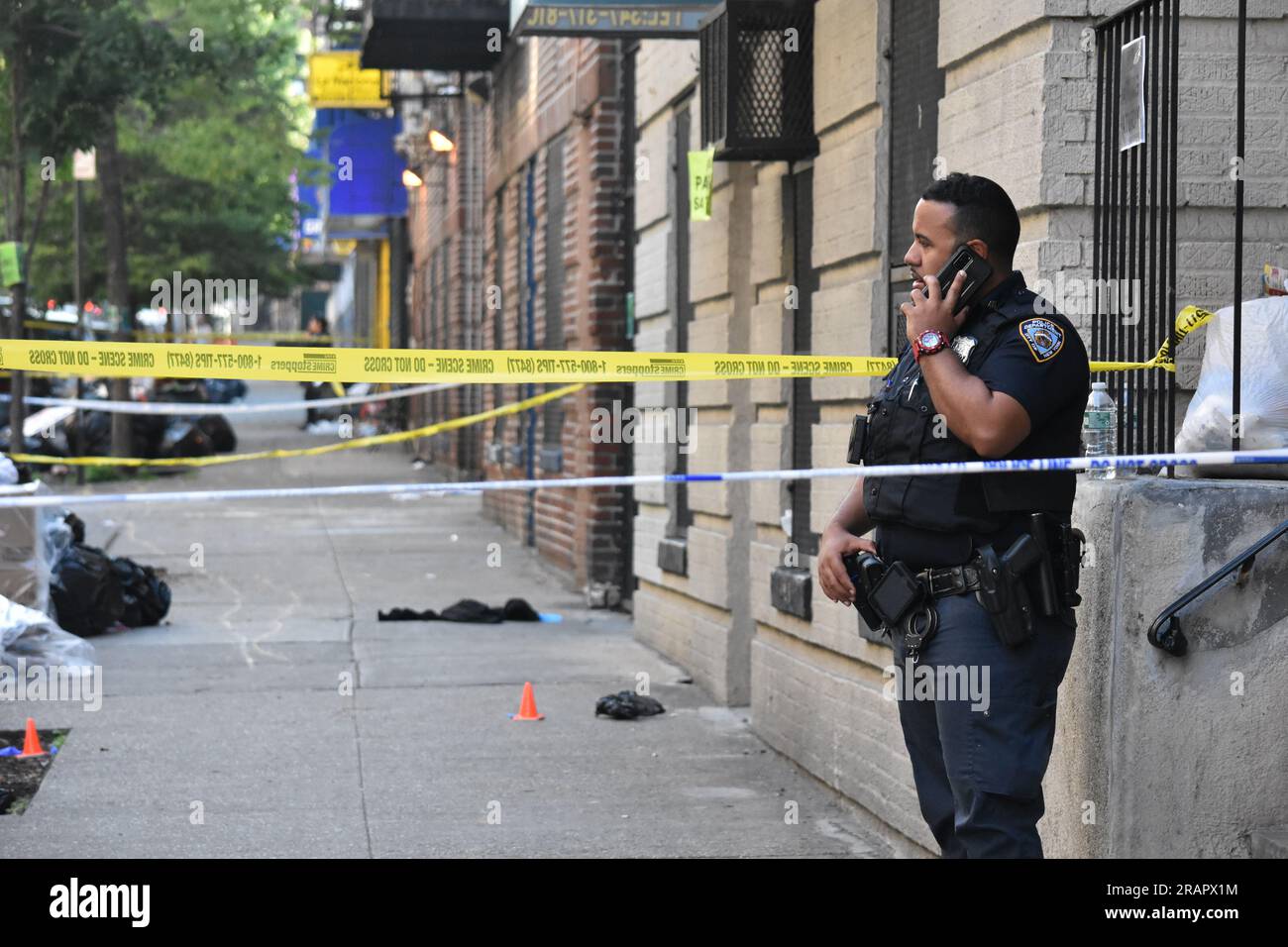 NYPD police officer guards the crime scene as evidence markers and police tape seen at the shooting incident. This shooting is part of a crime spree in which two people were killed