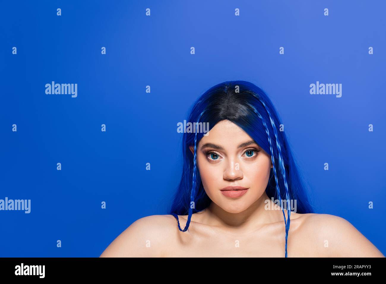 individualism, portrait of young woman with dyed hair and glowing skin posing on blue background, hair color, individualism, female model with makeup Stock Photo