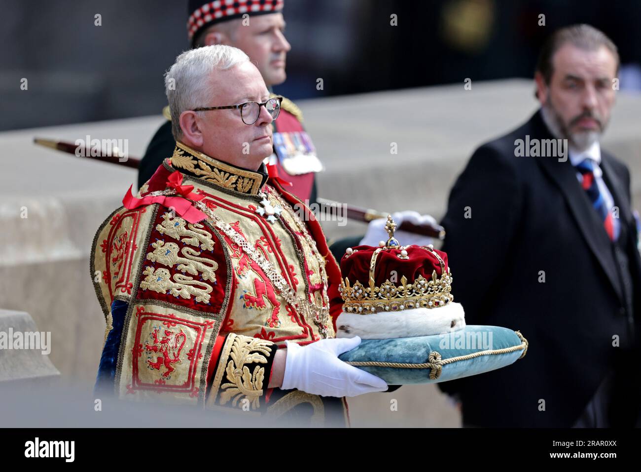 Lord Lyon King of Arms Joseph Morrow carrying the Crown, which forms