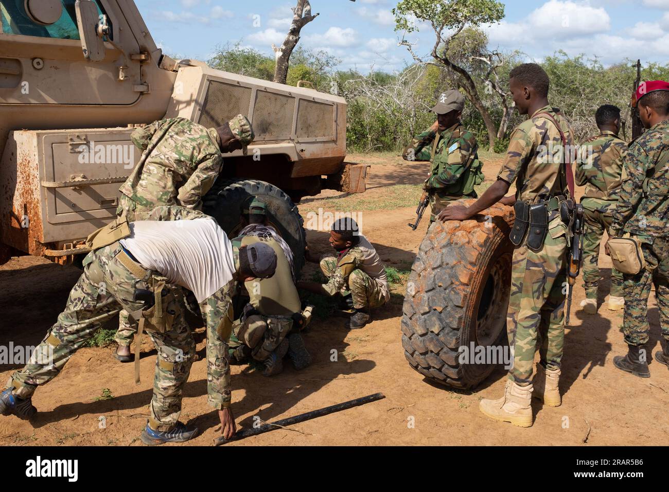 Somali soldiers change out a tyre on their Mamba APC in the bush, Southern Somalia Stock Photo