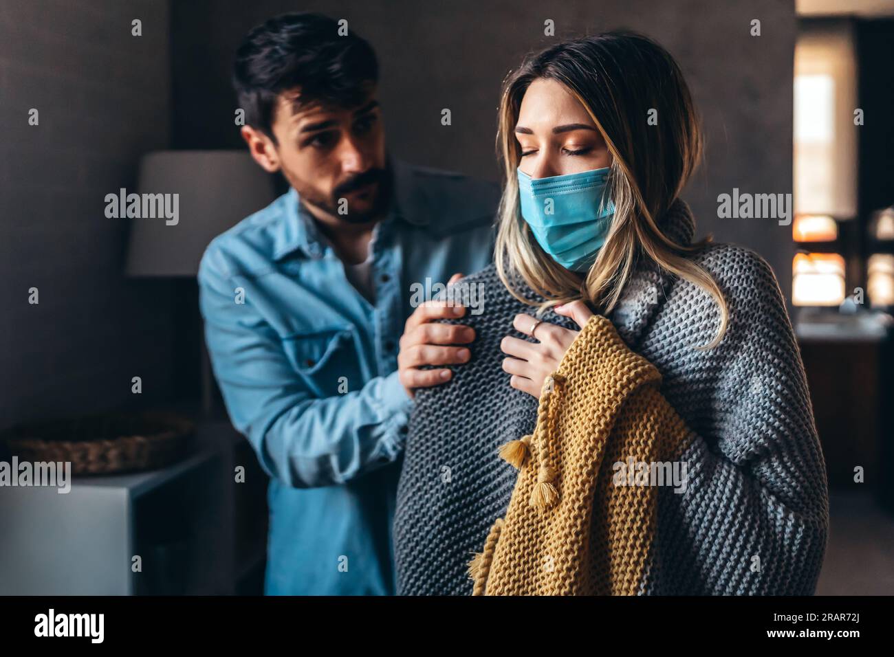 Freezing couple covered with a blanket. Man and a woman wrapped in a