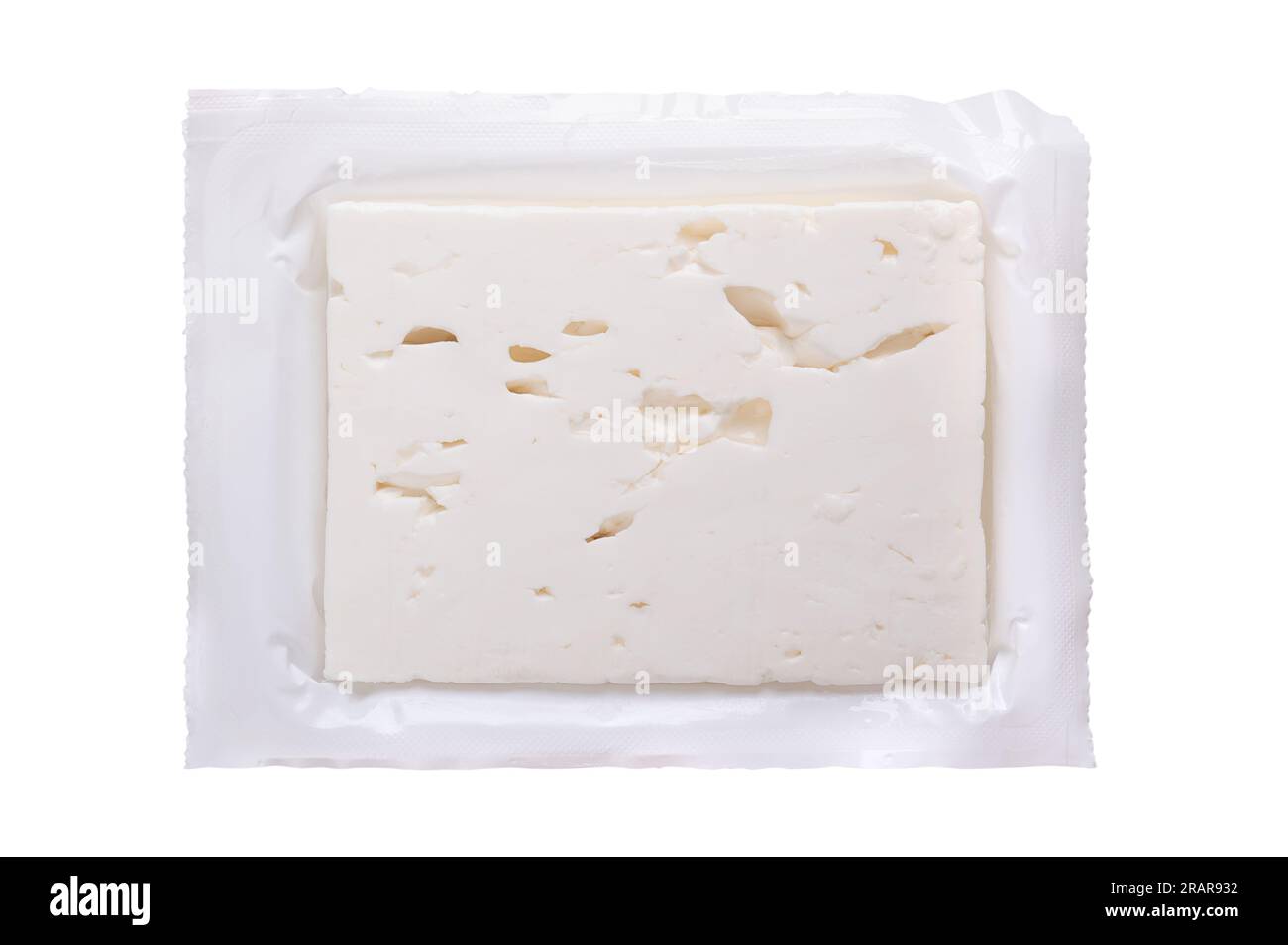 Greek feta block, brined cheese, in its opened original plastic wrap. Cheese, matured in brine, with soft and moist texture. Stock Photo