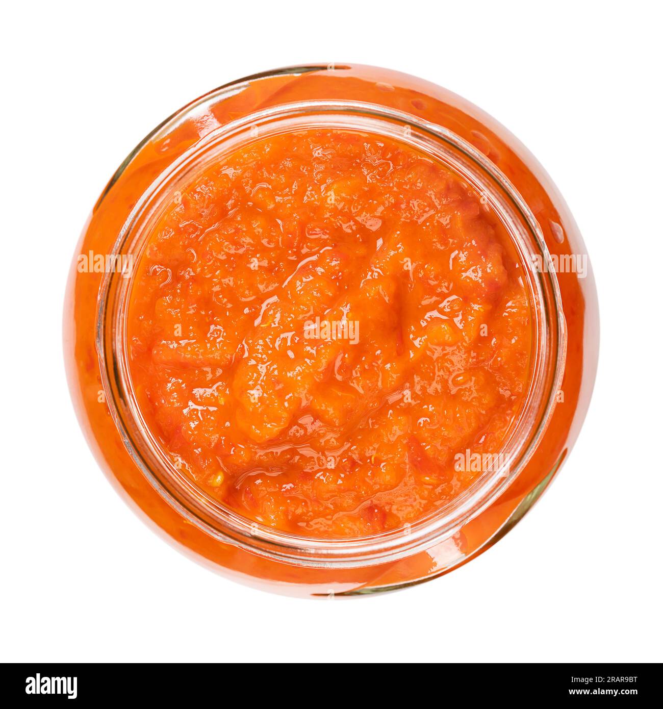 Ajvar, relish made of roasted sweet bell peppers, in a glass jar. Condiment, bread spread and side dish, popular in the Balkans. Stock Photo