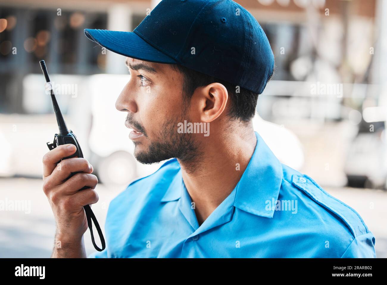 Security guard, safety officer or man on walkie talkie on a street for protection, patrol or watch. Law enforcement, serious and communication with Stock Photo