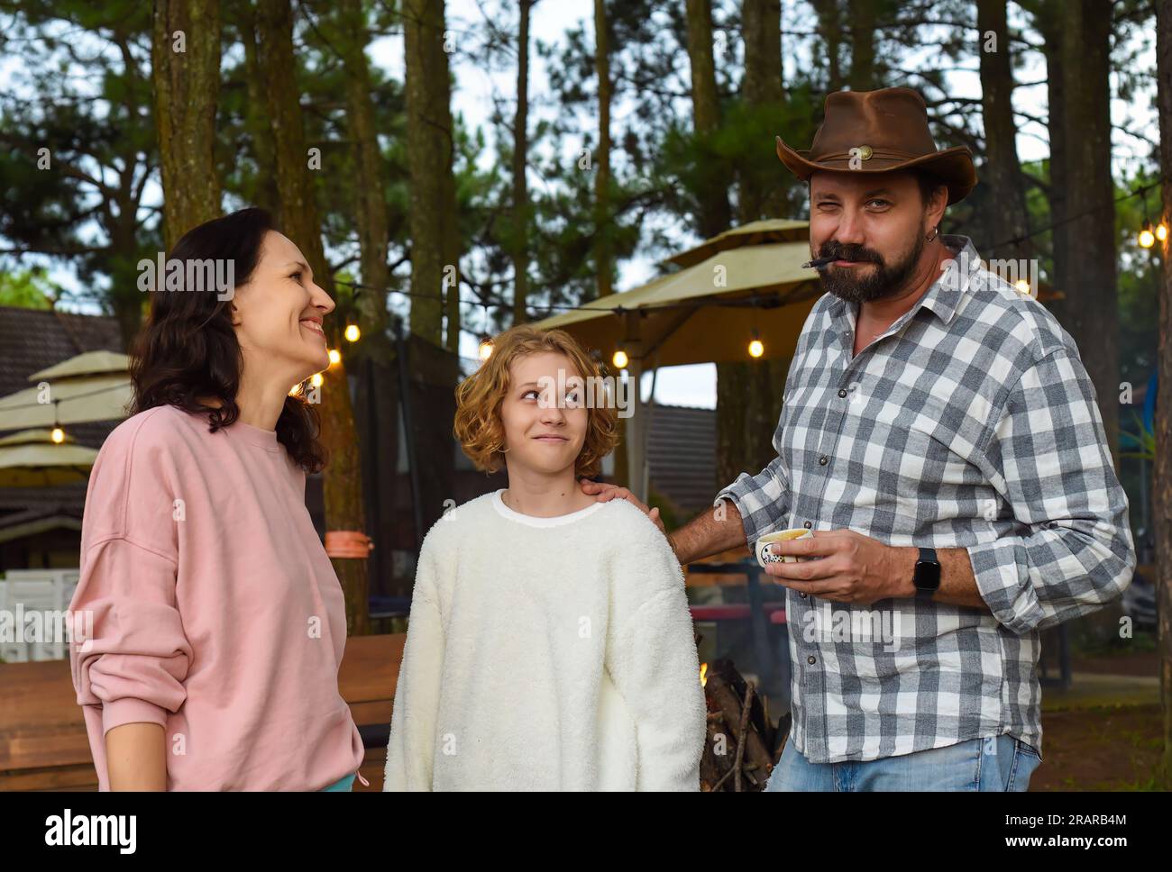 mother and daughter looking at dad fooling around and teasing Stock Photo