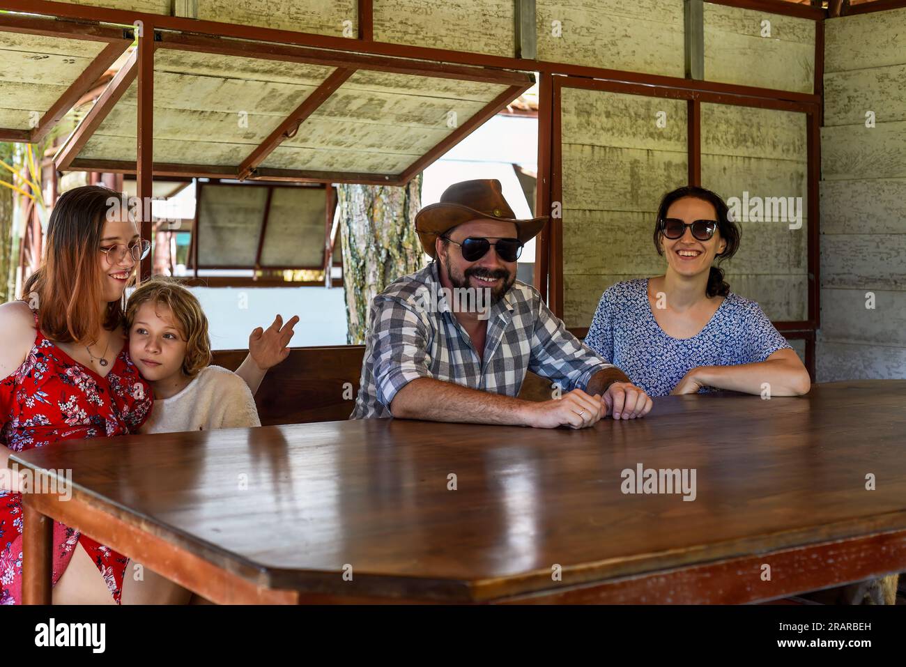 Family members father, mother and two daughters sit in alcove in park ...
