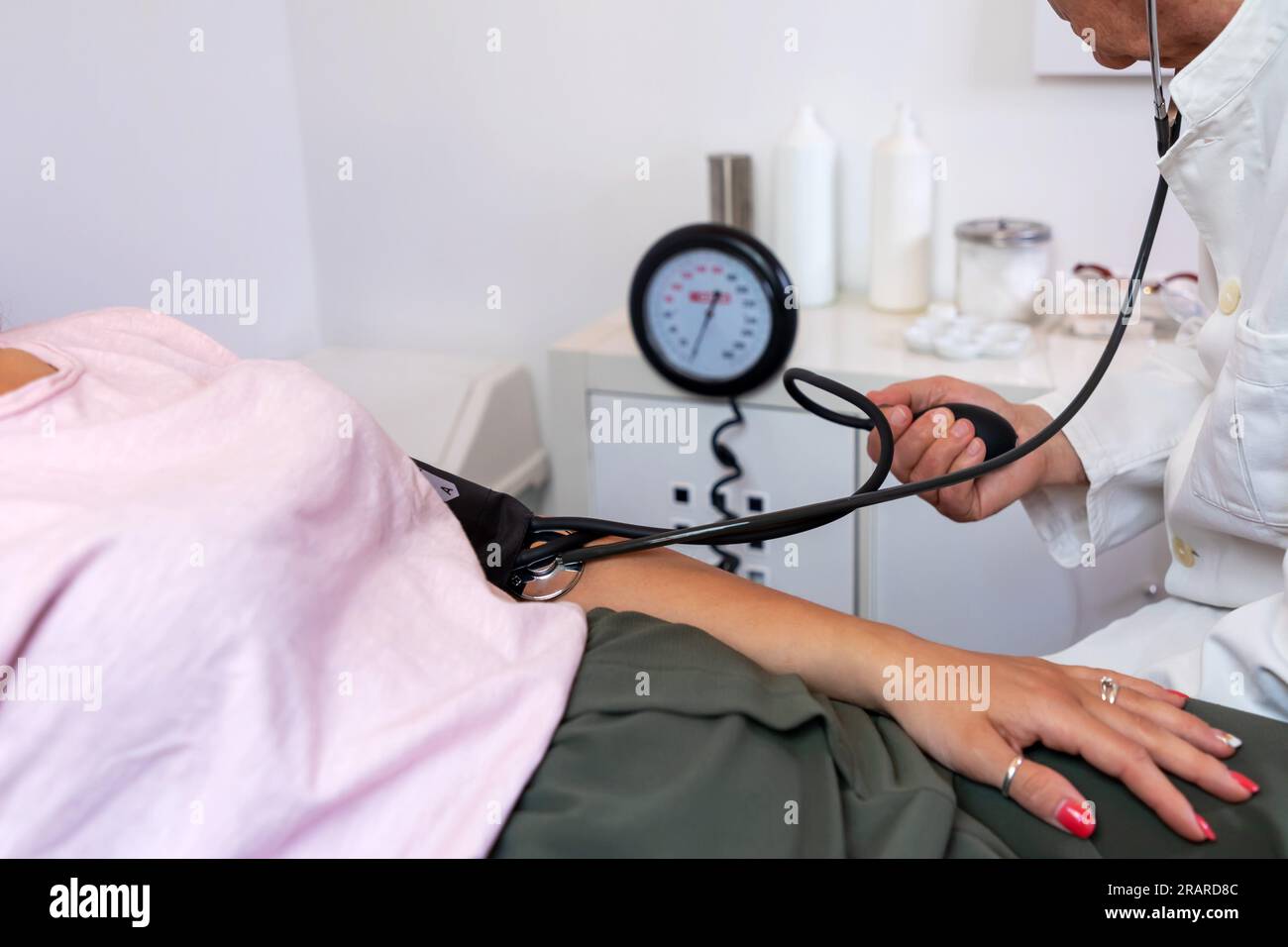 Doctor measures the blood pressure of the patient lying on the medical