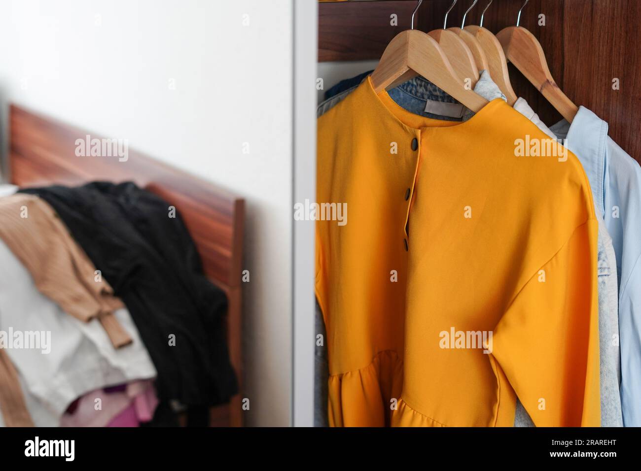 Brightly colored clothes on hangers in the closet. Decluttering the Stock Photo Alamy