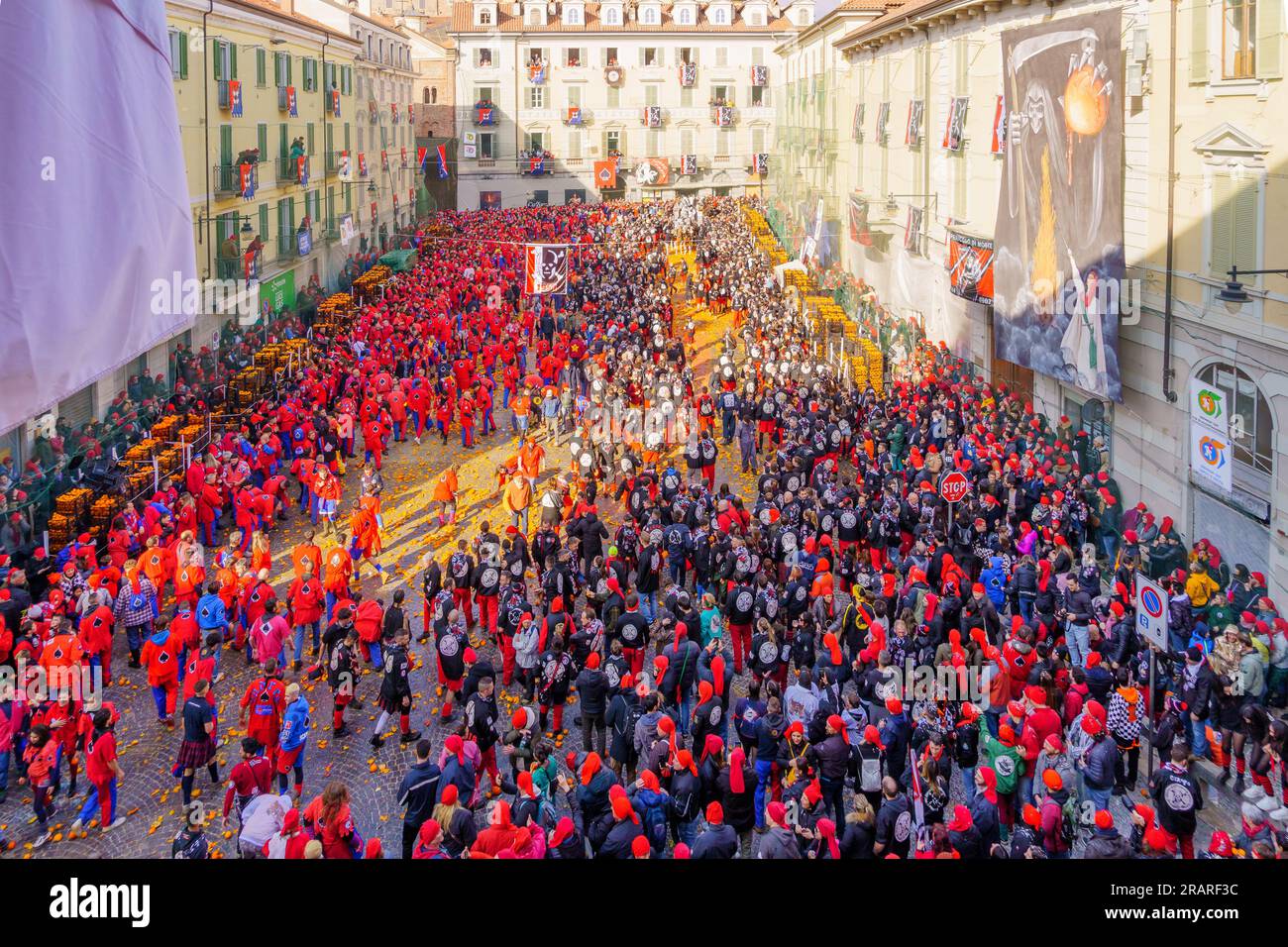 Ivrea, Italy - February 19, 2023: Battle of the Oranges scene of the town square (Piazza di Citta), with fighters and crowd, part of the historical ca Stock Photo