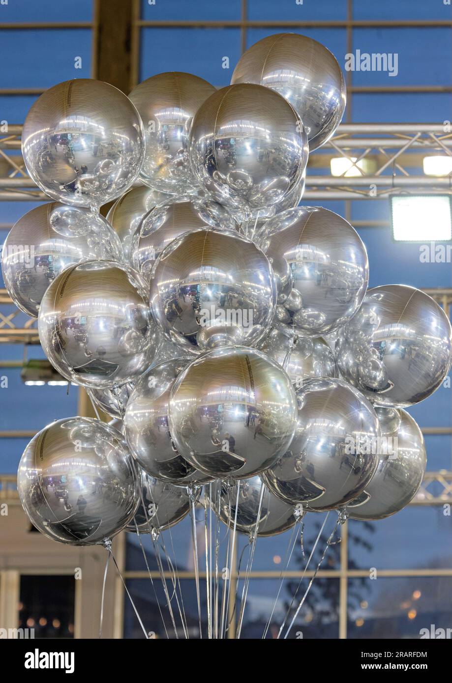 Cluster of Helium Filled Foil Silver Balloons in Hall Stock Photo
