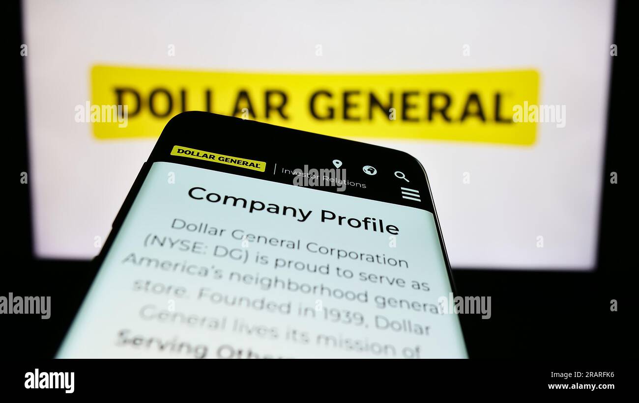 Mobile phone with website of US retail company Dollar General Corporation on screen in front of business logo. Focus on top-left of phone display. Stock Photo