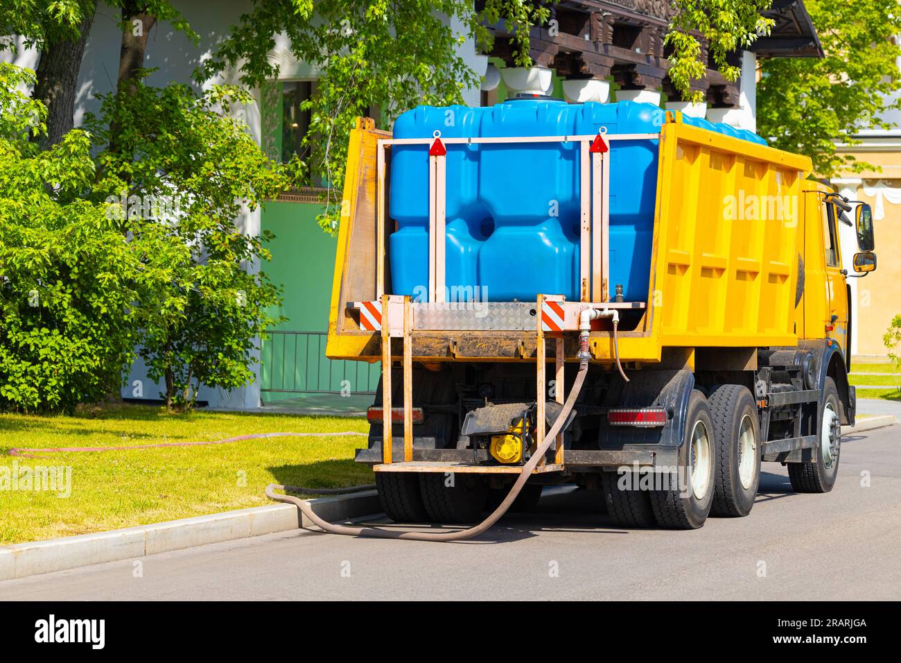 a large watering machine fills a tank with water. water tank machine
