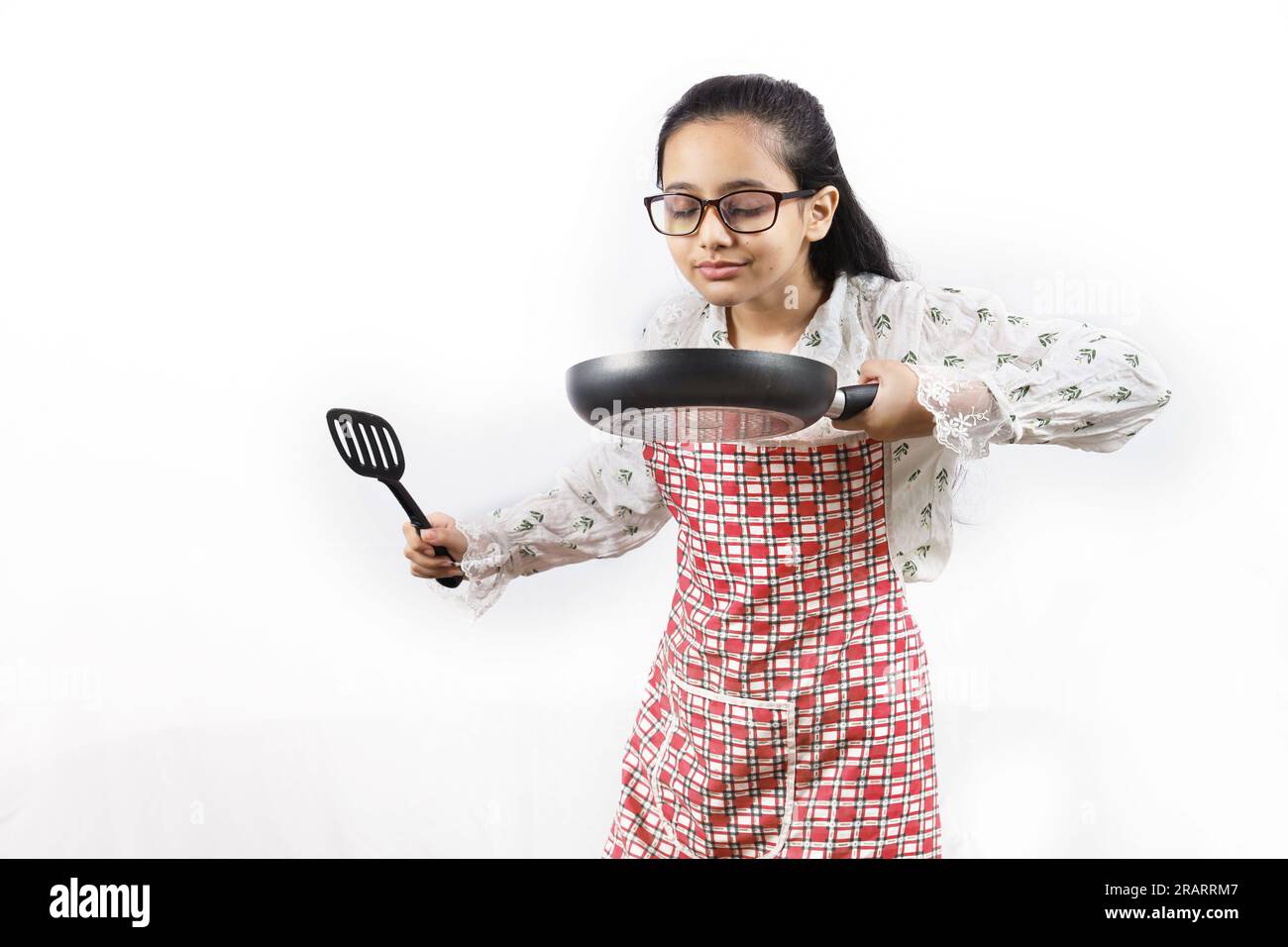 https://c8.alamy.com/comp/2RARRM7/portrait-of-happy-indian-teenage-girl-in-kitchen-holding-cooking-accessories-rolling-rin-frying-spoon-ladle-frying-pan-joyful-and-cheerful-young-2RARRM7.jpg