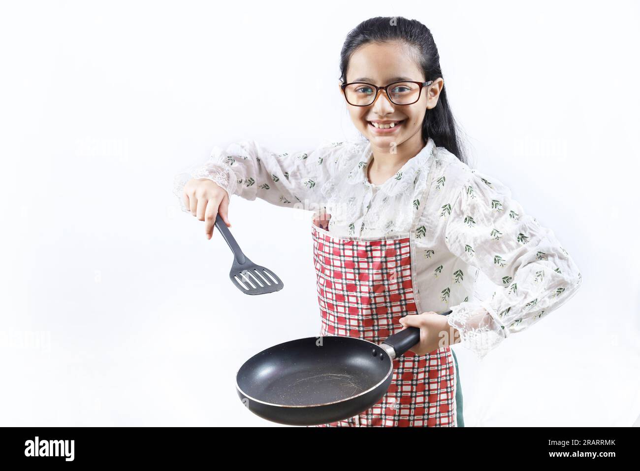 https://c8.alamy.com/comp/2RARRMK/portrait-of-happy-indian-teenage-girl-in-kitchen-holding-cooking-accessories-rolling-rin-frying-spoon-ladle-frying-pan-joyful-and-cheerful-young-2RARRMK.jpg