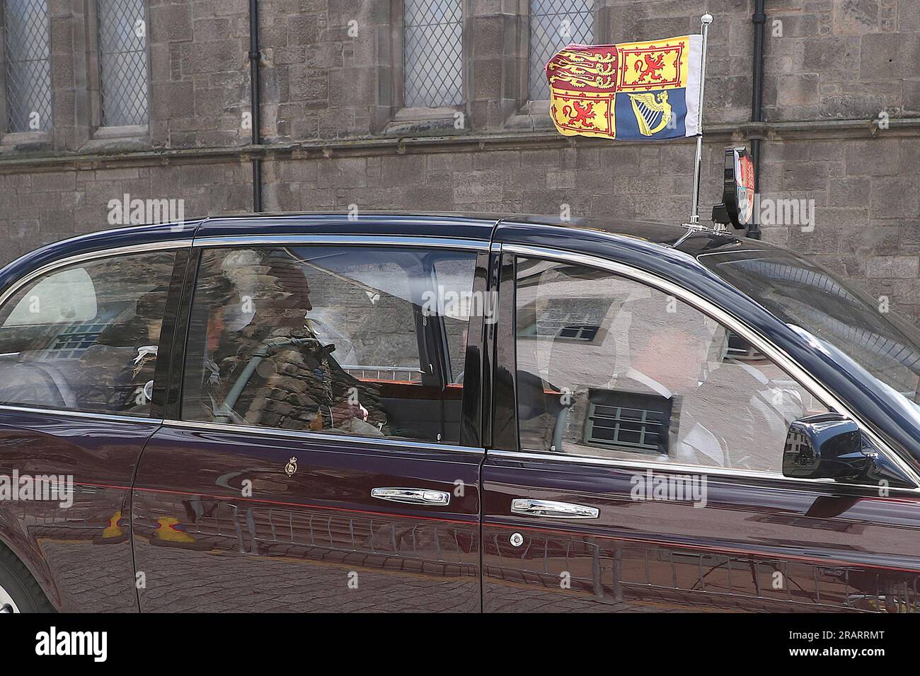 King Charles III and Queen Camilla are driven in a car from