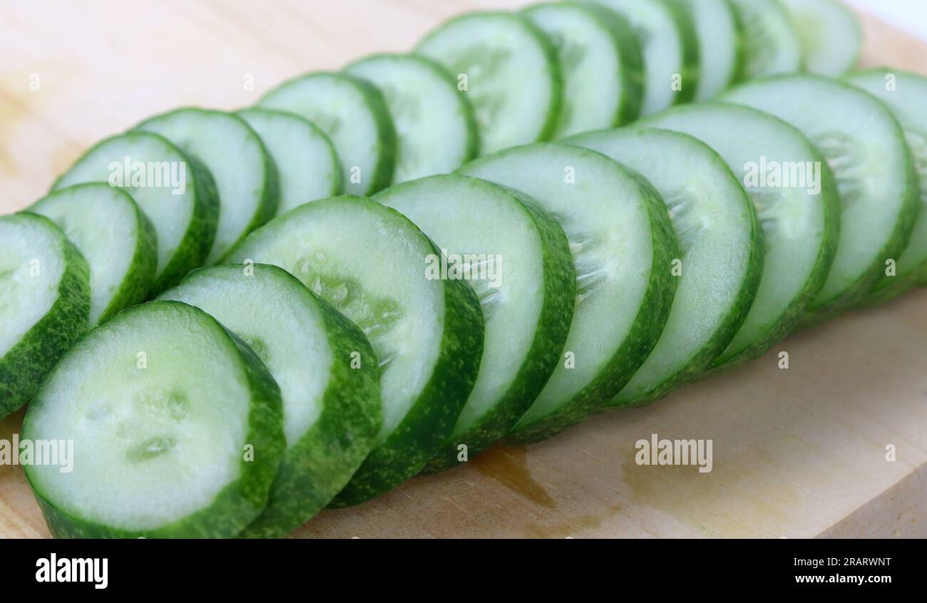 Fresh sliced cucumber on wood cutting board Stock Photo