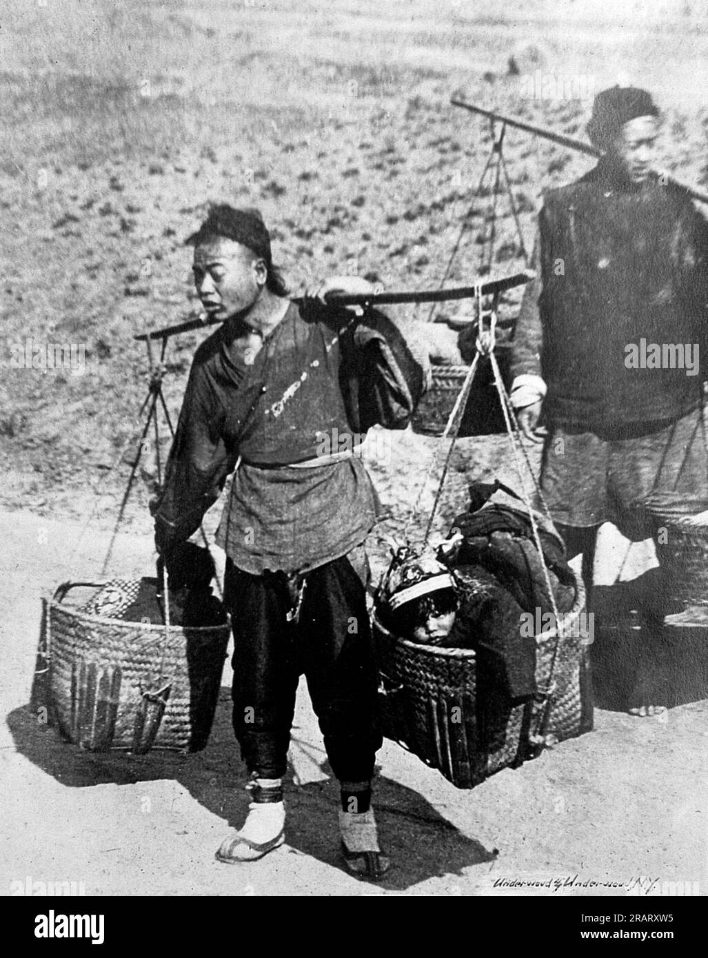 Chinese baby carriage a market basket slung on a pole. Market