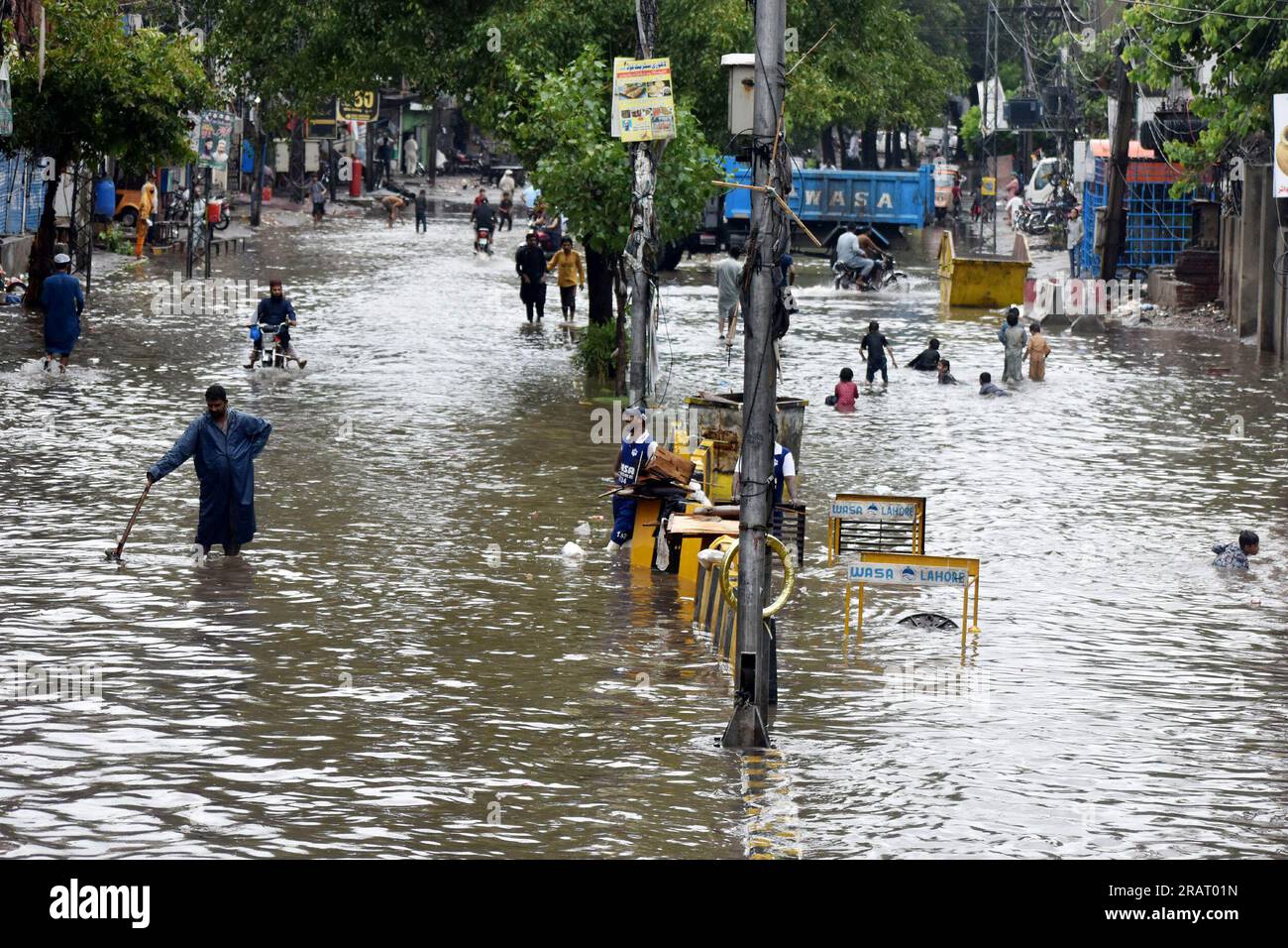 Lahore, Pakistan. 5th July, 2023. People wade through flooded water