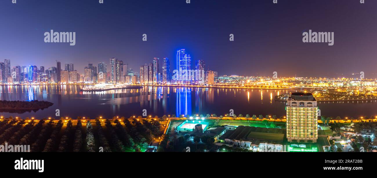 Panoramic view of Sharjah skyline in nighttime  at Dubai creek. Stock Photo